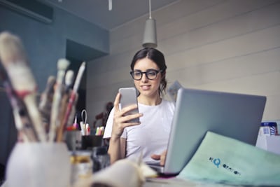 スマホとパソコンで作業する女性 SoftBank光申し込み